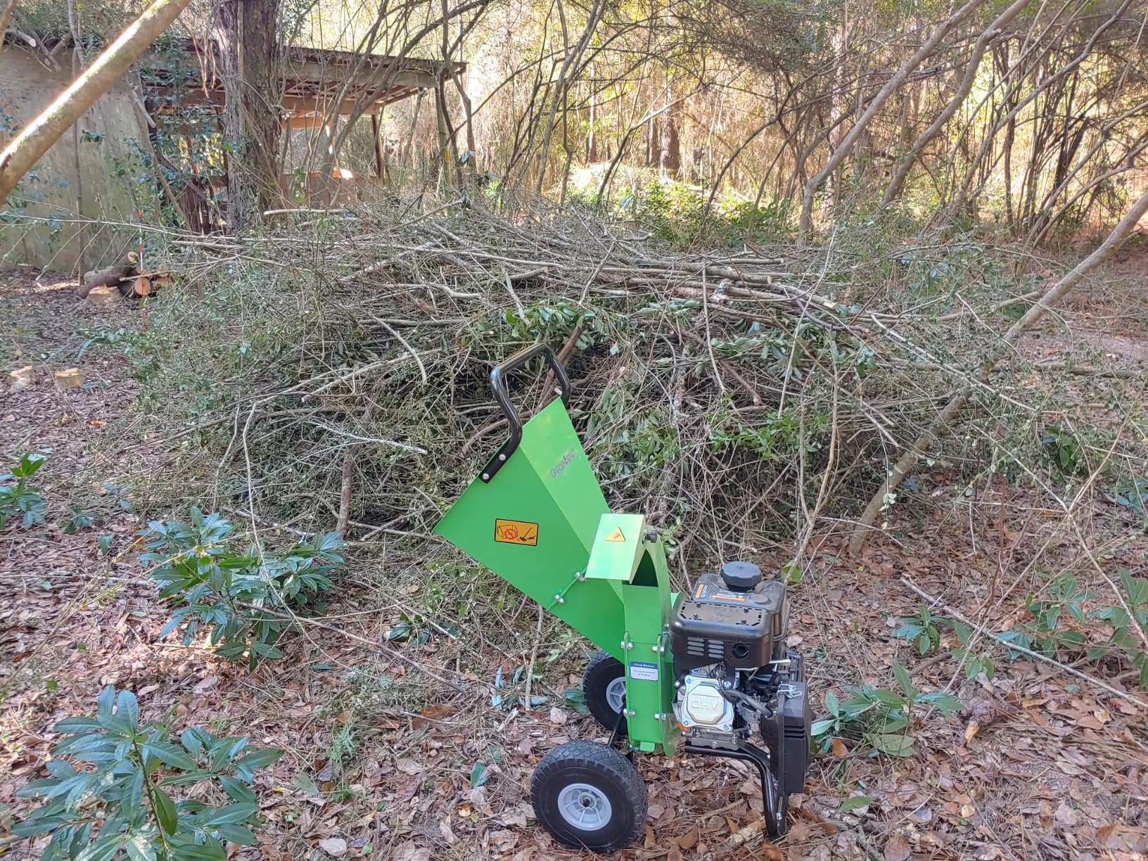 GardenBeaut chipper wheeled into the woods in front of a large brush pile